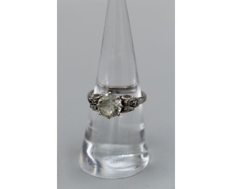 An Art Deco style raised setting colourless Zircon solitaire ring, with six eight cut diamond melee stones to the shoulders. 
