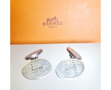 A pair of Hermes silver chain link cufflinks. Each featuring the "H" emblem of the house in black stippling. Each cufflink si