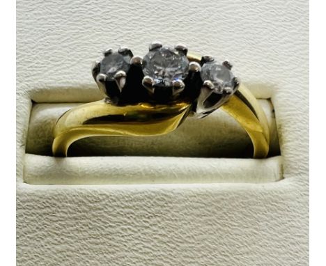 An 18ct gold three stone diamond ring. Estimated total weight of diamonds 0.25 carats, Size L. Approximate gross weight 3.7 g