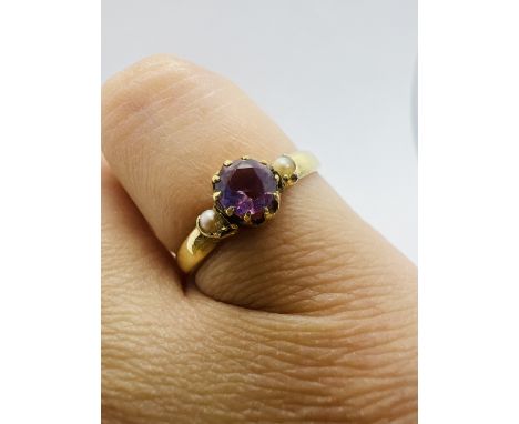 An amethyst and seed pearl ring in yellow metal. Stamped "15ct" to the shank. Size L. Approximate gross weight 2.2 grams.&nbs