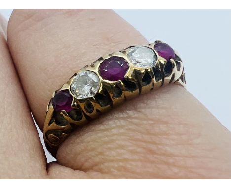 A 9ct gold ruby and diamond half hoop ring. Set with three round mixed cut rubies and two round brilliant cut rubies, both ap