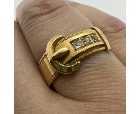 An Edwardian 18ct gold diamond set buckle ring. Featuring a complete good condition buckle, set with three old mine cut diamo