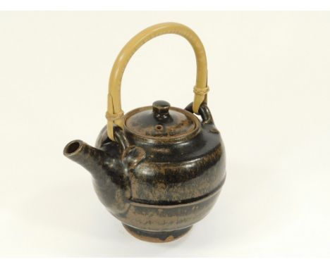 JIM MALONE. A Jim Malone tenmoku glazed, cane-handle teapot. Personal & Lessonhall marks. Width 19cm.  Please note that all i