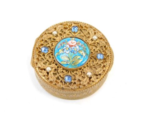 An Eastern inspired enamel pill box, the gilt floral design tops set with seed pearl and paste stones, with a central blue en