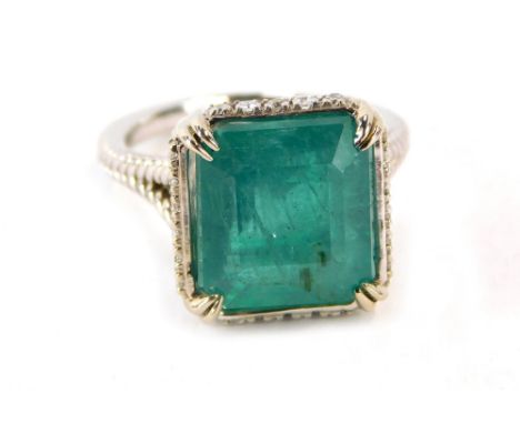 An emerald and diamond dress ring, with octagonal step cut emerald, measuring 12.10 x 11.11 x 8.77mm, totalling approx 8.59ct