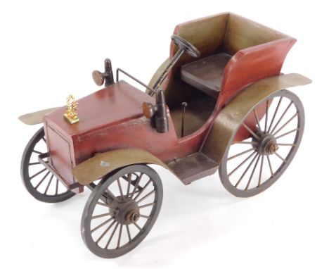 A model car, the main body made of wood, painted red, with metal applied supports, 30cm high, 44cm wide, 24cm deep.