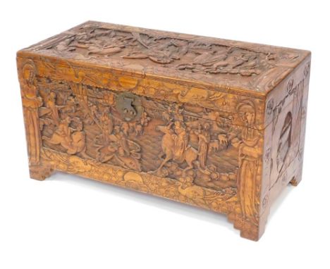 An early 20thC camphorwood chest, with carved oriental figures, central buckle, opening to reveal light out shelf, 59cm high,