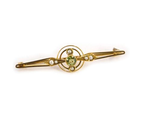 A peridot and seed pearl bar brooch, the central two twist circular emblem, with diamond shaped panels, with central peridot 