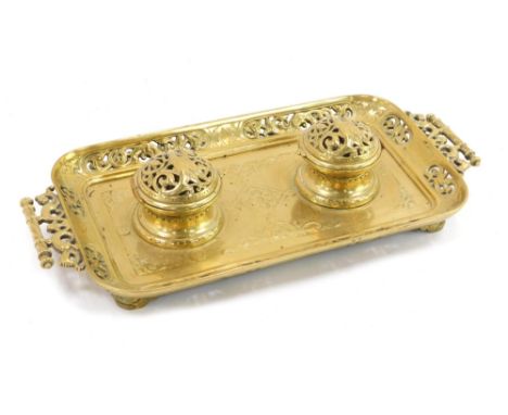 A late 19thC French brass inkwell, the rectangular tray with scroll leaf design, with two hinged brass lids, 40cm wide.