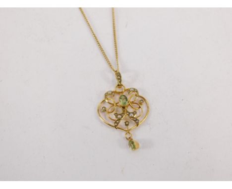 An Art Nouveau pendant and chain, the scroll design pendant set with seed pearl and peridot, 4cm high, on a 9ct gold curb lin