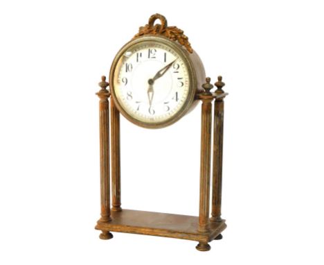 A Louis XVI style gilt metal mantel clock, the circular ceramic dial in a gilt casing with bow and acorn detailed top on four