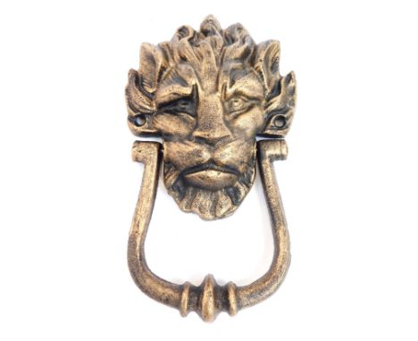 A lion mask brass effect door knocker, 20cm high.