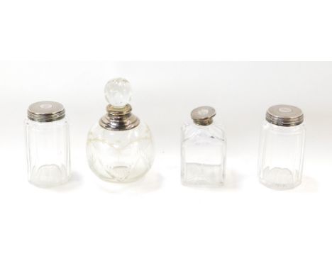 Three Victorian cut glass toilet jars, with silver lids, having engine turned decoration, circular central reserve, monogram 
