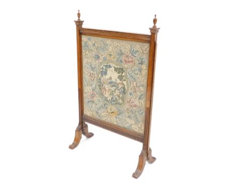 A carved oak tapestry firescreen, with finial tops, with a pleated and beaded border, the panel depicting male and female sea