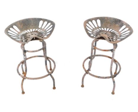 A pair of Pan and Botany swivel metal tractor seat bar stools, 65cm high, seats 47cm wide.