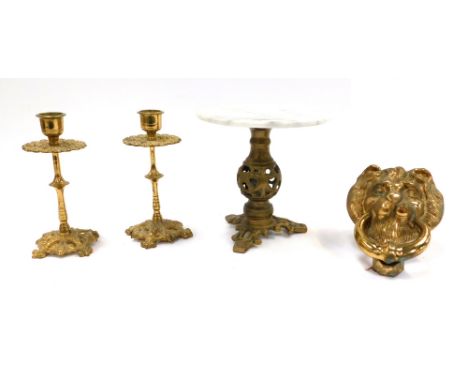 A group of brass ware, comprising a pair of Rococo style miniature candlesticks, 15cm high, a brass lion door knocker, 15cm h