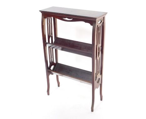 An Edwardian mahogany book trough, with fretwork sides, having two troughs, raised on slender cabriole legs, 59cm high, 57cm 