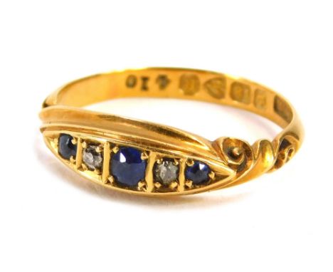 A Victorian 18ct gold gypsy ring, set with three sapphires and two round brilliant cut diamonds, with scroll design shoulders