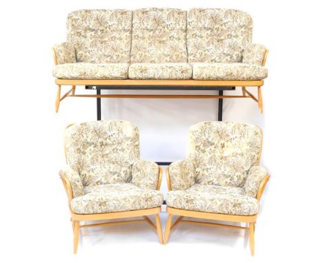 An Ercol light elm and beech Windsor three piece suite, comprising three seater sofa with floral upholstered cushion seats, 1