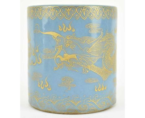 A Chinese powder-blue ground cylindrical brush pot decorated in gilt with ruyi clouds to the rim, dragon chasing flaming pear