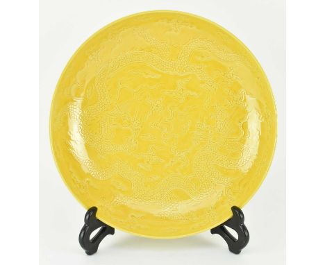 A Imperial yellow-glazed ceramic incised 'dragon' charger plate. The chager with egg yolk yellow glaze, potted with shallow c