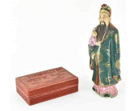 An early 20th century Chinese cinnabar lacquered papier mache box and cover, the rectangular box decorated with two men amids