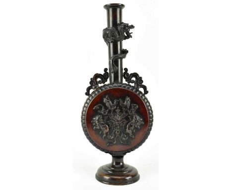 A Japanese Meiji Period heavy bronze moon flask. The flask vase featuring curled dragon twisted around neck, twin scrolled fo