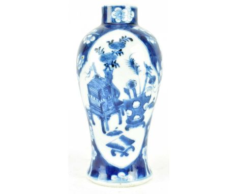 A Qing dynasty blue &amp; white ceramic vase. The baluster-shaped vase decorated with two open panels depicting antique vases