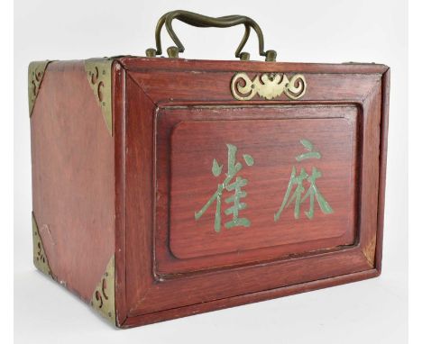 A 1920s Mahjong set. The wooden brass-mounted case with carrying handle and sliding front with Chinese characters, opening to