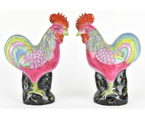 A pair of Qing dynasty famille rose ceramic rooster figurines. Each rooster decorated with colourful paint, &amp; standing on