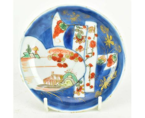 A small Qing Kangxi blue and white copper red ceramic saucer. The circular saucer decorated with landscape, flowers and grape