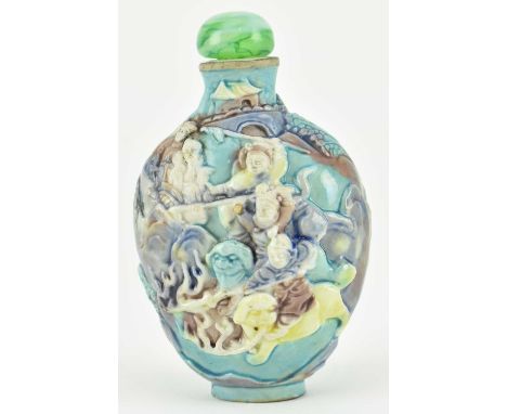 A relief porcelain figurine snuff bottle. The bottle decorated with relief "Warriors" figures amidst rocks cape and trees wit