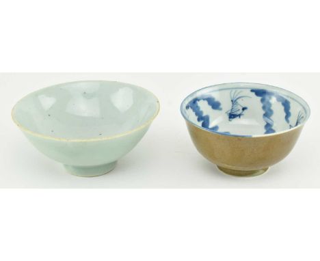 A Qing dynasty cafe au lait glazed ceramic bowl. The bowl decorated with blue and white hand painted fishes and algae to the 