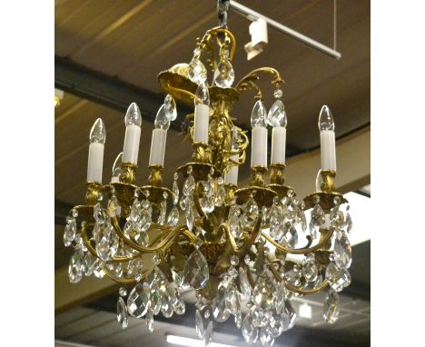 A modern brass effect chandelier with cut glass drops