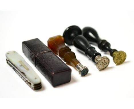 A 19th century agate hand seal, two ebonised wood examples, and a mother of pearl combination knife, cased Pocket knife - Mad
