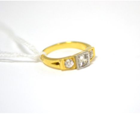 A diamond three stone ring, the graduated old cut diamonds in white and yellow squared settings, on a split shouldered plain 