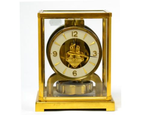 A brass atmos clock, signed Jaeger LeCoultre, 20th century, glazed panels, 4-1/4-inch dial, large balance wheel below and a s