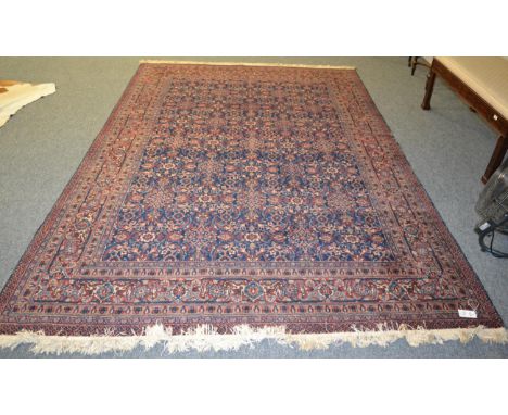 A Tabriz carpet, Iranian Azerbaijan, the indigo lattice field of curling leaves, vines and flower heads enclosed by samovar b