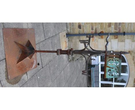 A weather vane, dated 1873 in a weathered copper panel 