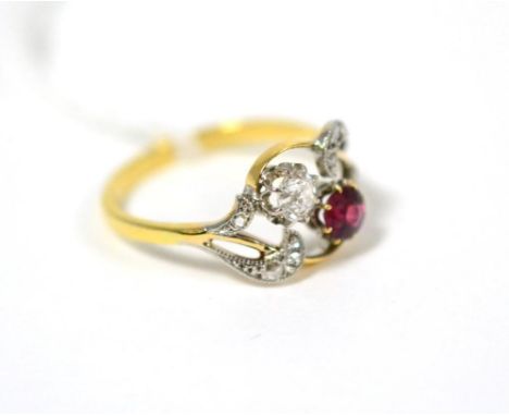 A ruby and diamond cluster ring, a round cut ruby and an old cut diamond in white claw settings to rose cut diamond set scrol