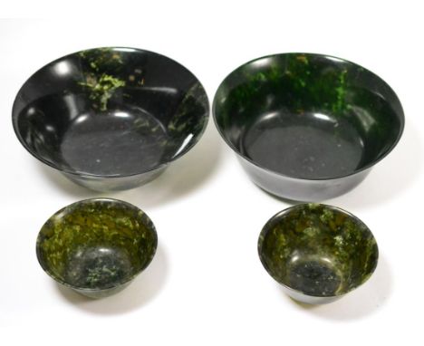 A pair of Chinese spinach jade small bowls, 18cm diameter, and two larger examples, 10cm diameter  Provenance: Part of the M.