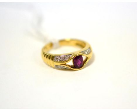 A ruby and diamond ring, an oval cut ruby in yellow half rubbed over setting to an open frame, within a border of white pavé 