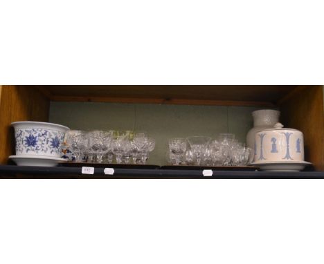 A shelf including assorted crystal and cut drinking glasses, a Wedgwood jardiniere, Chinese jardiniere, crackle glaze vase et