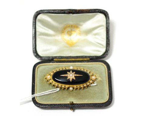 A onyx and split pearl mourning brooch, the oval onyx inset with a seed pearl star motif, within a border of seed pearls with