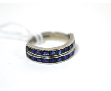 An 18ct white gold sapphire two row ring, the step cut sapphires in channel settings, on a (later) plain polished shank, fing