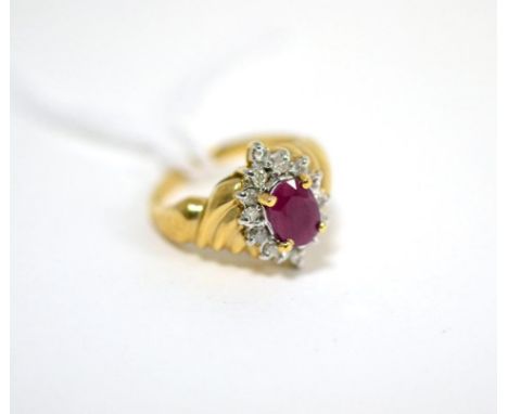 A ruby ring, an oval cut ruby in a yellow claw setting within a border of round brilliant cut diamonds in white claw settings