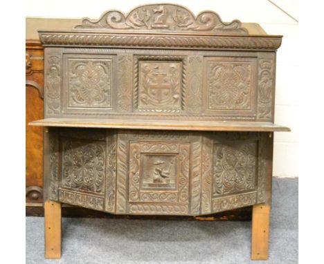 An 18th century carved oak panel, the upper section with two fielded panels around a coat of arms carved with 'Martis Non Cup