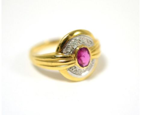 A ruby and diamond ring, an oval cut ruby in a yellow rubbed over setting, to a part diamond set border, and grooved shoulder