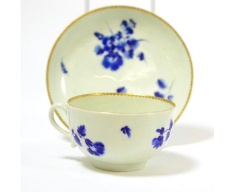 A First Period Worcester tea cup and saucer, Giles decorated in dry blue with flower sprays, bears cross swords mark