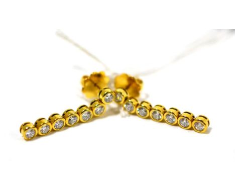 A pair of diamond drop earrings, each with seven round brilliant cut diamonds in yellow rubbed over settings, total estimated